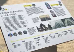Un panneau d'interprétation du patrimoine avec une chronologie, des photos d'archives et du texte